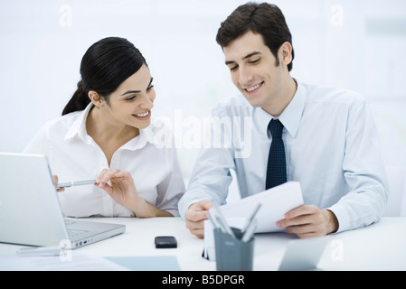 Kollegen zusammen sitzen am Schreibtisch, auf der Suche im Dokument, Lächeln Stockfoto
