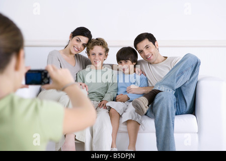 Junges Mädchen nehmen Foto von ihren Eltern und Brüdern Zusammensitzen auf sofa Stockfoto