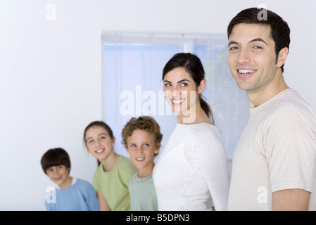 Familie zu höchsten kürzeste aufgereiht, mit Blick auf Vater, Vater lächelnd in die Kamera Stockfoto