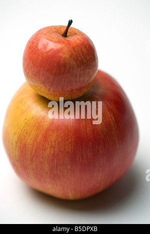 Kleiner roter Apfel auf größere Apfel Stockfoto