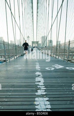 Jogger, die Fußgängerzone der Brooklyn Bridge in New York City Skyline von Manhattan in Ferne quer Stockfoto