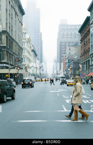 Fußgänger überqueren Straße in Zebrastreifen bei W 19th Street und 6th Avenue, Chelsea, New York, nach NE Stockfoto