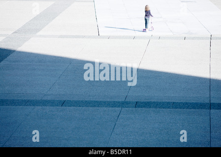 Kleines Kind reiten Push Scooter alleine auf öffentlichen Platz Stockfoto