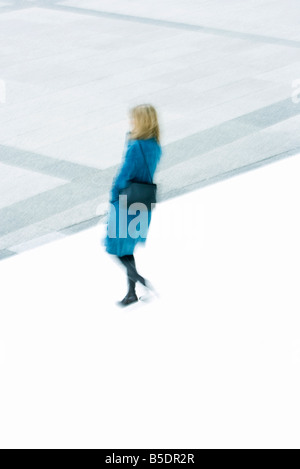 Frau im blauen Mantel absteigend Treppe Stockfoto