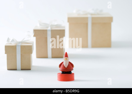 Santa Claus Figur stand vor Weihnachtsgeschenke Stockfoto