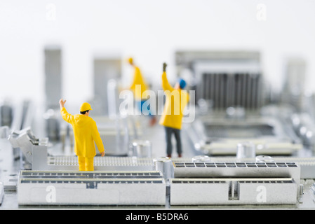 Miniatur-Techniker stehen auf Computer-Motherboard mit erhobenen Armen Stockfoto