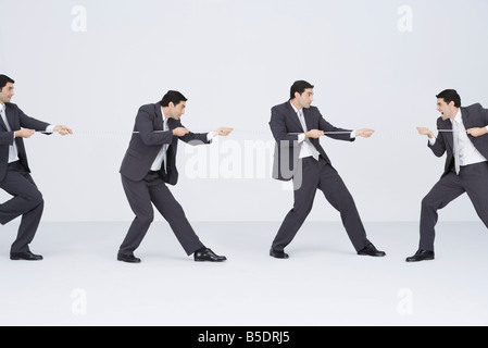Geschäftsmann spielen Tauziehen mit den Klonen von Self, digital composite Stockfoto