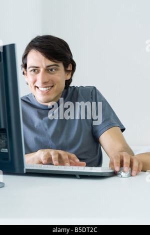 Mann mit Desktop-Computer, Lächeln Stockfoto