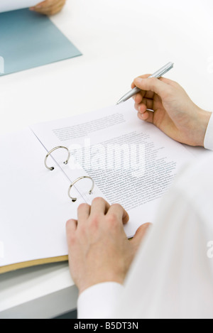 Mann überprüfen Dokuments in der Sammelmappe, über die Schulter-Blick, beschnitten Stockfoto