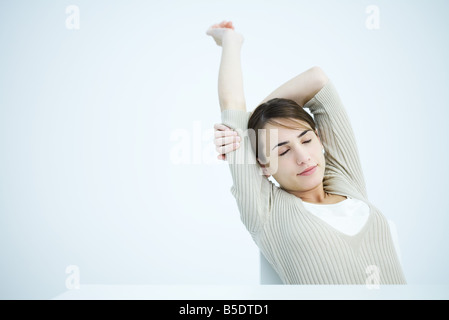 Frau streckte Arme, Augen geschlossen Stockfoto