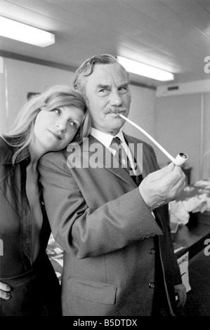 Pfeife rauchen-Champion Robert Locke von Hayes, Middlesex, verfolgt Schreibkraft Liliana Perez, wie der TV-Werbung während der britischen nationalen Pfeife rauchen Meisterschaft. ; Mai 1975 Stockfoto