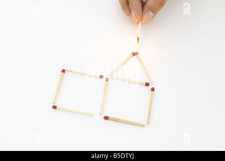 Hand halten beleuchtet mit Haus aus Streichhölzer Stockfoto