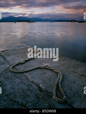 Flut an Port Appin Pier mit einer Aussicht auf die Berge und Hügel des Ardgour bei Sonnenuntergang. Stockfoto