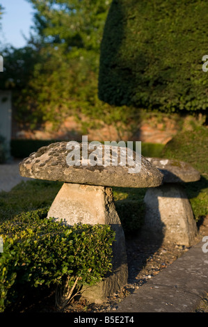 Ein paar der Pilz geformt Staddle Steinen vor einem Haus in Wiltshire Stockfoto