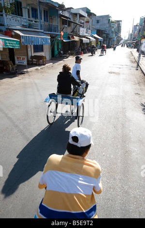 Junge Frau mit Cyclo-Taxi in die Stadt von Chau Doc im Mekong-Delta, Vietnam Stockfoto