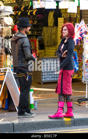 London, Camden Lock Market hübschen weiblichen Punk-Mädchen mit rosa Haaren Rock, Tattoo & Schnürstiefel & gepiercte Gesicht mit jungen im Hut Stockfoto