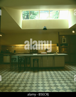 Graue & weiße Schachbrettmuster Bodenbelag in großen modernen Keller Küche mit rechteckigen Insel Einheit und Downlight Stockfoto