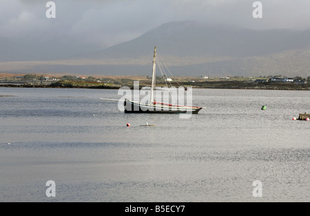 Currach Fischerboot Roundstone Bucht die Maamturk Mountains im Hintergrund Roundstone Connemara, County Galway, Irland Stockfoto