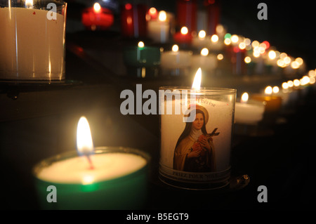 Kerzen mit einem Jungfrau-Symbol brennen in einer Kirche in Zentral-Frankreich Stockfoto