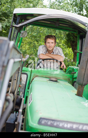 Landwirt in Traktor sitzen Stockfoto