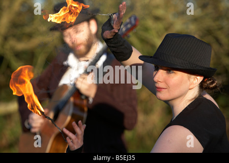 Mann, die Gitarre mit Firepoise Frau Feuer Tänzerin Spiel mit dem Feuer spielen Stockfoto