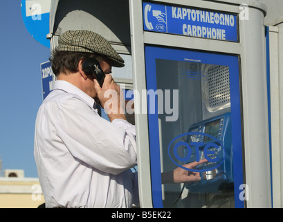Mann an einer öffentlichen Telefonzelle in Rhodos, Griechenland Stockfoto