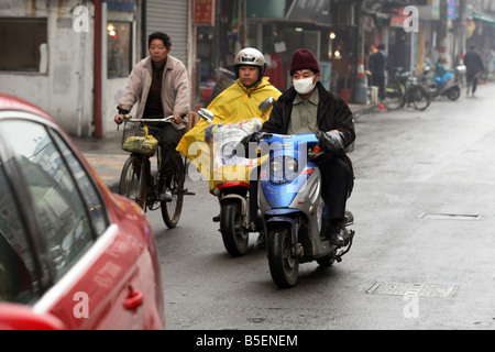 Menschen auf Roller Auto Trog Shanghai, China Stockfoto