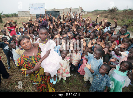 Die Mutter von Victoria Climbie präsentiert stolz eine Schule im Namen ihrer Tochter Bertha Climbie ist hier abgebildet, hält Victoria s Schwester Joelle und ist umgeben von zukünftigen Schüler der Schule die ich in Abobo die Côte d ' Ivoire im September 2008 eröffnet wird gebaut Stockfoto