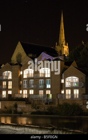 Appartements am Ufer des Flusses Wear in Durham, England. In der Nacht mit einer Kirche im Hintergrund genommen. Stockfoto