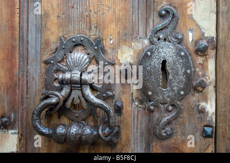 Eine alte Türklopfer und Sperre für eine ramponierte alte Haustür in Boulogne, Frankreich Stockfoto