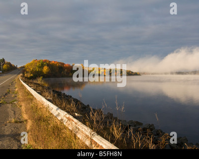 Schwere Morgennebel entlang des St. John River im Herbst mit Herbstfarben Herbstfarben in New Brunswick, Kanada Stockfoto