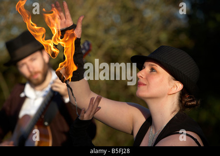 Mann, die Gitarre mit Firepoise Frau Feuer Tänzerin Spiel mit dem Feuer spielen Stockfoto