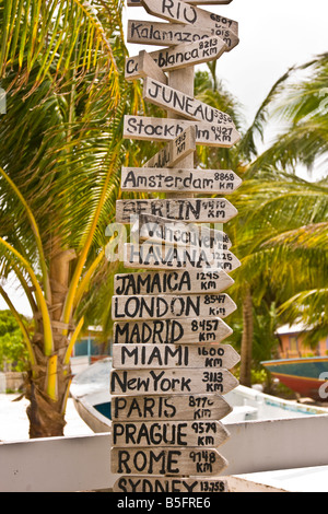 CAYE CAULKER BELIZE Sign Post mit vielen Zeichen, die Entfernung in Kilometern zu Großstädten auf der ganzen Welt auflisten Stockfoto