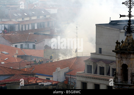 Feuerwehrleute auf dem Dach einer Wohnung in Brand in der Stadt Bilbao Vizcaya Nordspanien Stockfoto