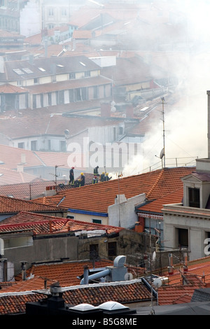 Feuerwehrleute auf dem Dach einer Wohnung in Brand in der Stadt Bilbao Vizcaya Nordspanien Stockfoto