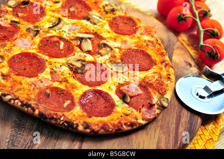 Frisch gebackene Peperoni-Pizza auf Holzbrett Stockfoto