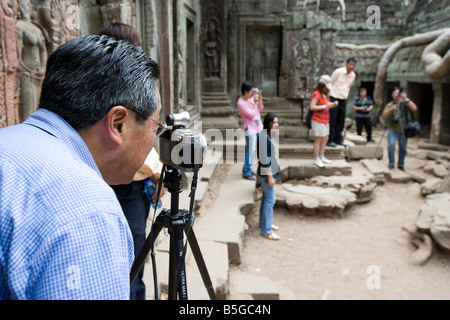 Besucher im Inneren die überwucherten Tempel der Ta Prohm Tempel von Angkor Siem Reap Kambodscha Stockfoto