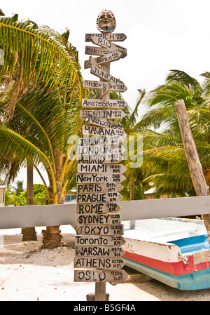 CAYE CAULKER BELIZE Sign Post mit vielen Zeichen, die Entfernung in Kilometern zu Großstädten auf der ganzen Welt auflisten Stockfoto
