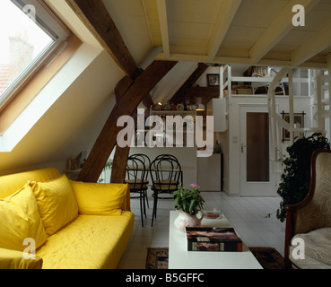Leuchtend gelben Sofa unter Velux Fenster in offene Dachgeschoss Wohnzimmer und Küche in traditionellen Wohnung Stockfoto