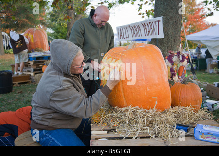 Eine Frau aus Nalls Bauernhofmarkt schnitzt einen Kürbis 2008 Shenandoah Valley Heißluftballon und Weinfest in Virginia. Stockfoto