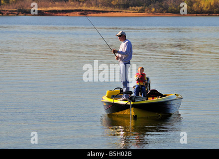 Ein Vater Fische aus seinen Bass Boot, während sein kleiner Sohn Uhren. Arcadia Lake, Oklahoma, USA. Stockfoto
