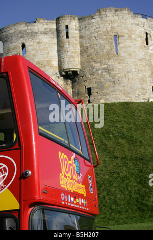 City of York, England. York City Sightseeing Bus mit Clifford es Tower an der York Burganlage im Hintergrund. Stockfoto