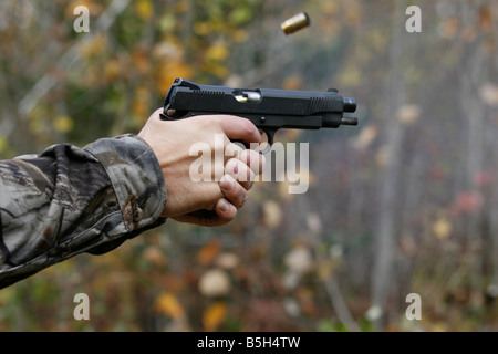 Nahaufnahme einer Colt 45 halbautomatische Pistole abgefeuert mit der leeren Hülse wird ausgeworfen. Stockfoto