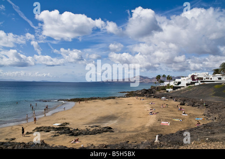 dh Strand PUERTO DEL CARMEN LANZAROTE Sonnenanbeter auf kleine Lava Stein Sand Strand Stockfoto