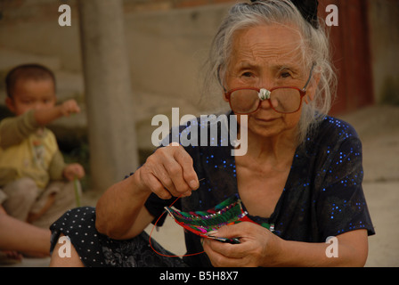 Eine Frau tribal Miao (Hmong) Minderheit im Dorf Xijang, Guizho Provinz, China führt Handarbeiten. Stockfoto