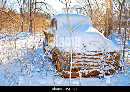 Ein alter verrosteter LKW unter einem Haufen Neuschnee. Stockfoto