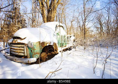 Ein alter verrosteter LKW unter einem Haufen Neuschnee. Stockfoto