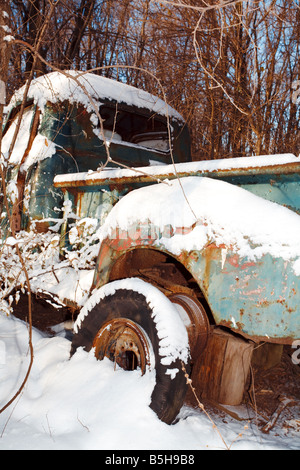 Ein alter verrosteter LKW unter einem Haufen Neuschnee. Stockfoto