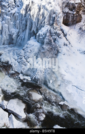 Eiskalte Wasser rauscht durch einen gefrorenen Wasserfall. Stockfoto