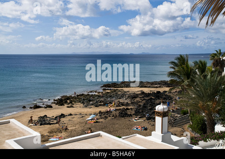 dh Strand PUERTO DEL CARMEN LANZAROTE Sonnenanbeter auf kleine Lava Stein Sand Strand Stockfoto